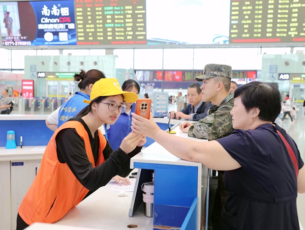 南宁东站志愿者解答旅客问询。于莉摄