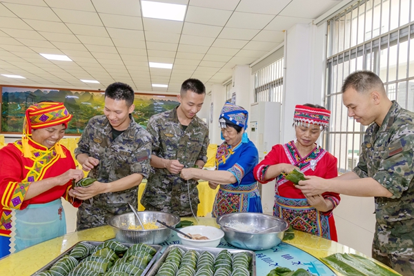群众教武警官兵包粽子。