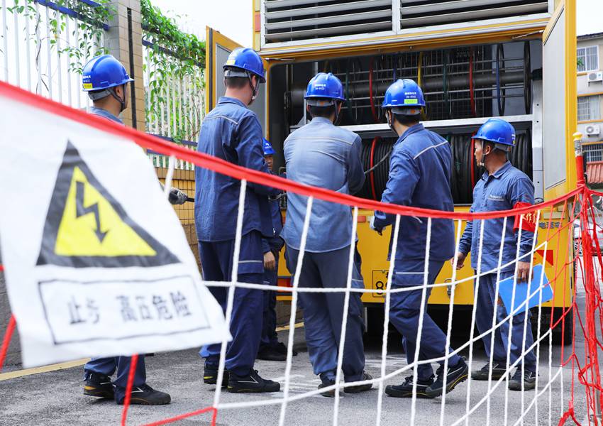 柳州柳城供电局工作人员配合将应急发电车接入考点供电设施。梁琪摄