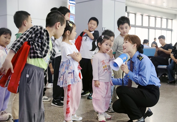 图为:5月31日,桂林火车站工作人员向小旅客宣传文明出行小知识。郑长贤摄