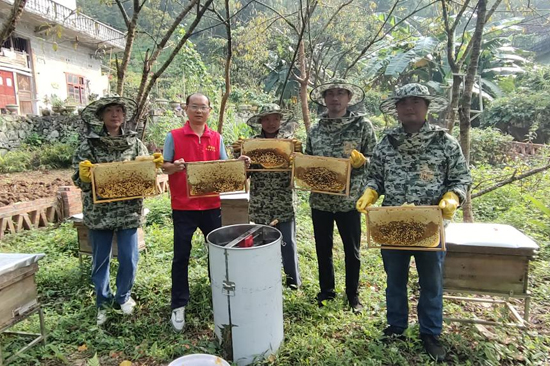 温昌盛（左二）和村民在加八屯蜂蜜丰收现场。黄莹静摄