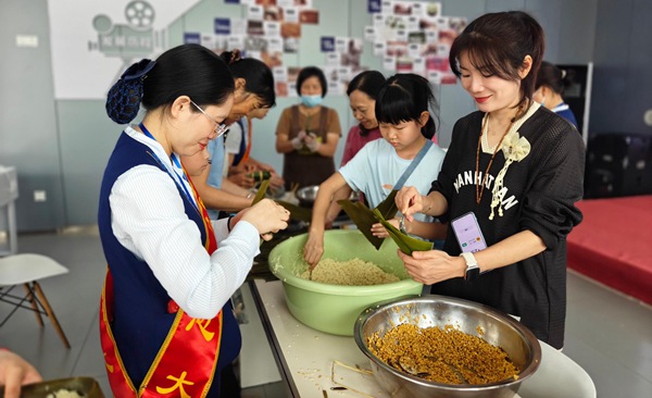 贺州建设东路营业厅爱心大使带领大家包粽子。罗雪妃摄