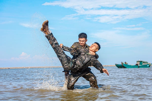 武警官兵在海水中进行擒敌对抗训练。