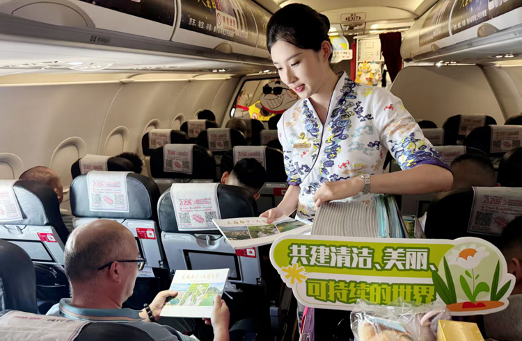 乘务员向旅客派发生态环境宣传册