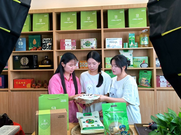 图为梁仙梅老师（左）在蓝家屯与学生讲解直播要点