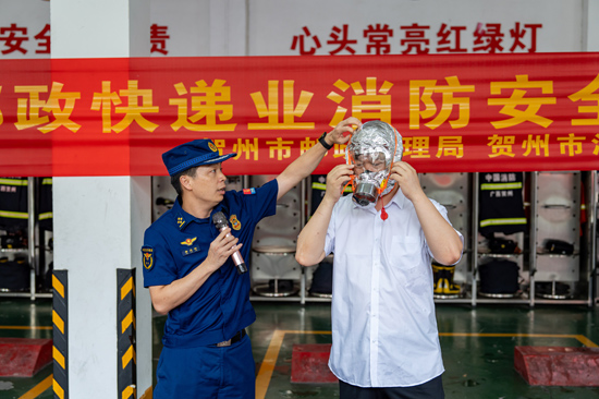 消防监督员教授行业人员如何正确佩戴防毒呼吸面罩。邱晓宇摄