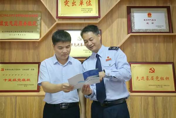 图为贺州市税务局党委委员、总经济师吴海峰（右）到企业调研，并开展政策宣传辅导