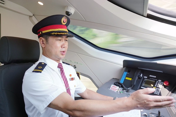 羅志忠正在駕駛室裡操縱列車。江曉攝