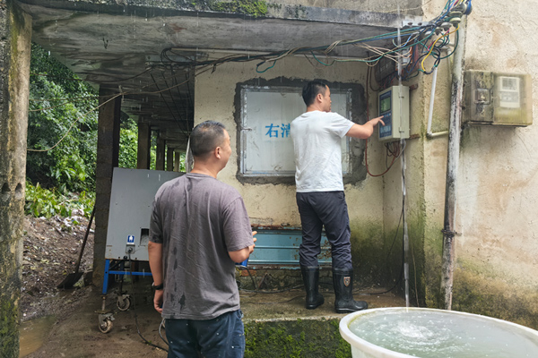 烟技员正在检查烤房控制器。杨绍基摄
