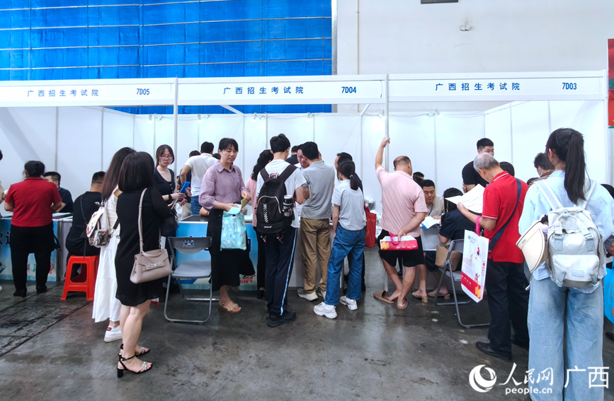 在广西招生考试院展位，工作人员为家长及考生答疑解惑。