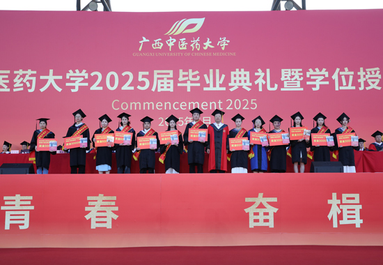 莫锦荣书记为西部计划志愿者赠书。广西中医药大学供图