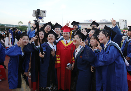 姚春校长与毕业生们合影。广西中医药大学供图