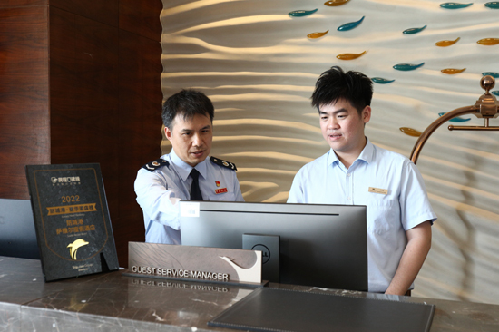 防城港市防城区税务局税宣团队成员指导酒店会计人员进行电子税务局发票额度调整申请。
