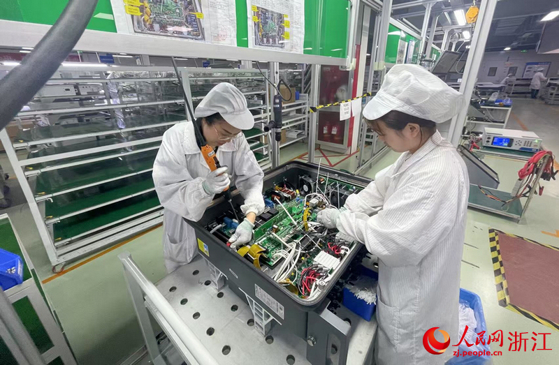在组装车间，工人们正在安装逆变器
