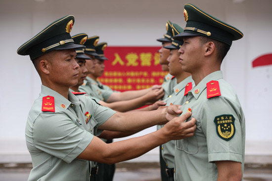 老党员为新党员佩戴党员徽章。王超智摄