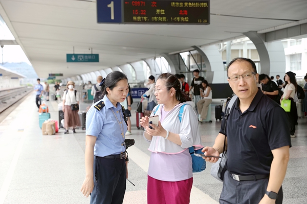 桂林站客運工作人員為旅客答疑解惑。鄭長賢攝