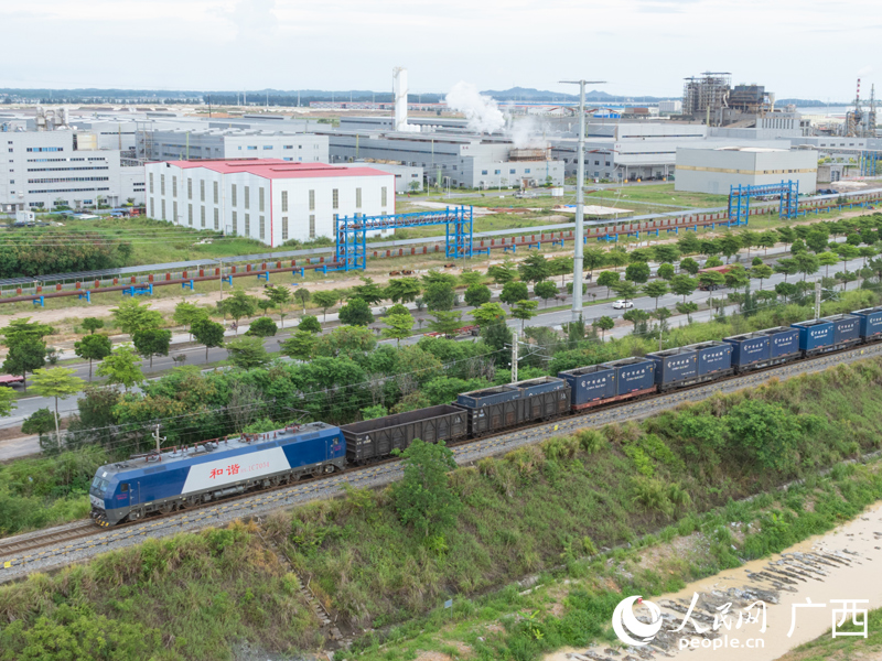 图为一趟满载集装箱货物的西部陆海新通道铁海联运班列，从钦州港东站缓缓驶出。