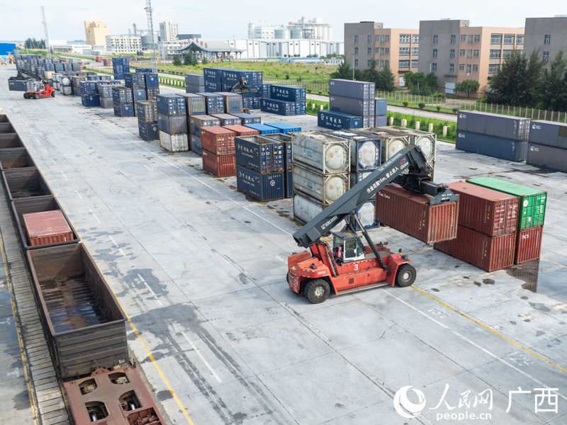 图为钦州铁路集装箱中心站内，一台正面吊正在装卸集装箱货物。
