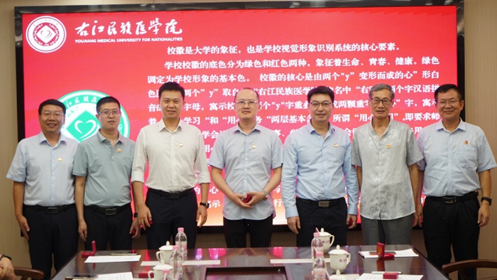 李雪斌、王俊利为杰出校友代表赠送并佩戴校徽。右江民族医学院供图