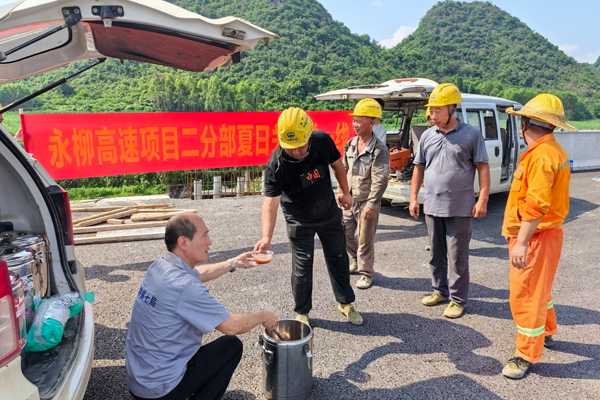 工会工作人员为工人送上绿豆汤。王鹏摄