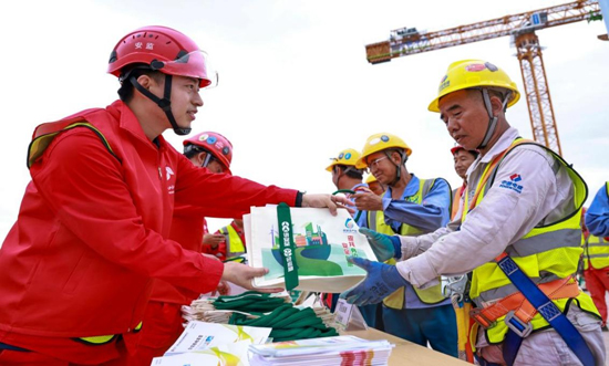 向工友科普职业病知识，发放安全知识手册。国家电投广西核电公司供图