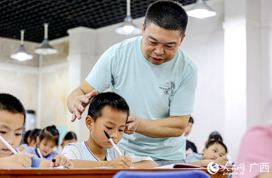 老师正在纠正孩子们练字的坐姿。