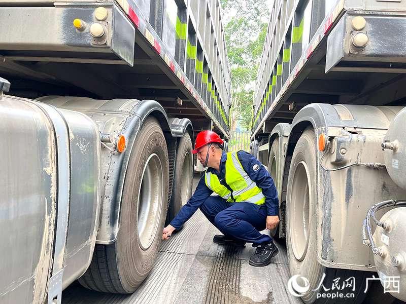出发前，韦征仔细检查车况。人民网 韦欢摄