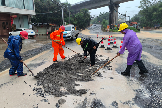 防城公路养护中心养护人员在S312茅岭镇街头紧急处理路面坑槽。黄乃锋摄