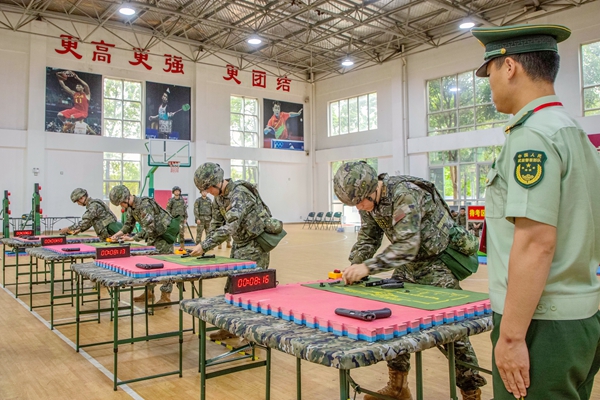 武警官兵在进行武器分解结合考核。