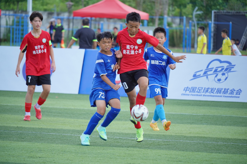 南宁市桃花源小学对阵合肥师范附小教育集团第二小学,10号黄源骏在比赛中奋力拼抢。杨代勇摄