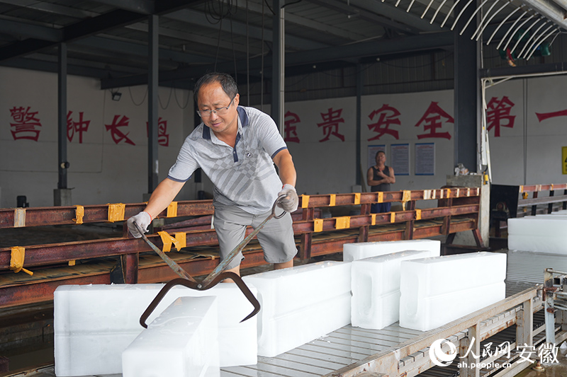 工人夹取冰块运向货车