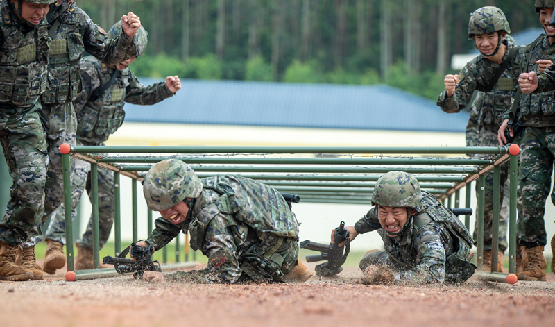武警官兵在进行通过地桩网训练。王斐摄