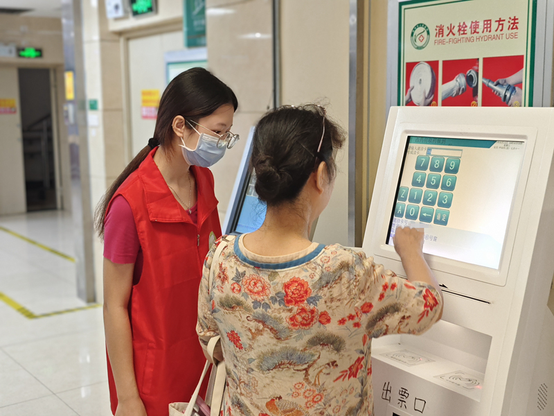 贺州市人民医院志愿者指导患者使用自助一体机取号缴费。贺州市人民医院供图