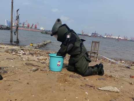 排爆手緩慢將爆炸物轉移至事先裝有抗振物的水桶內。李聰攝