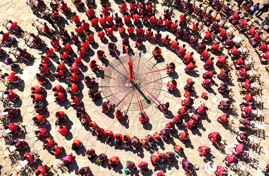 瑶族妇女在展示红瑶服饰制作工艺。