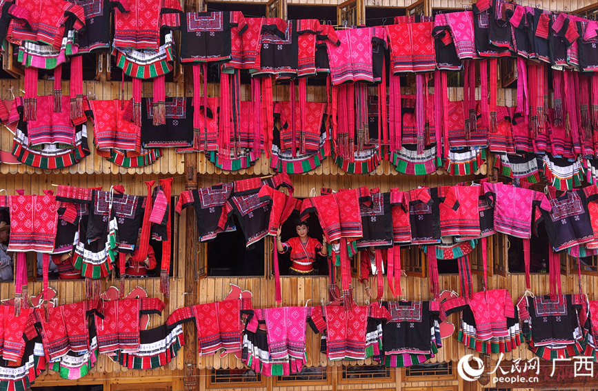 瑶族妇女在吊脚楼上晾晒花衣花裙。