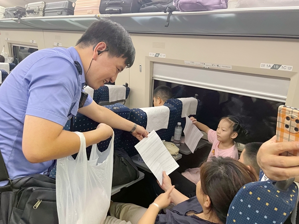 覃雲昊為小旅客發試卷。