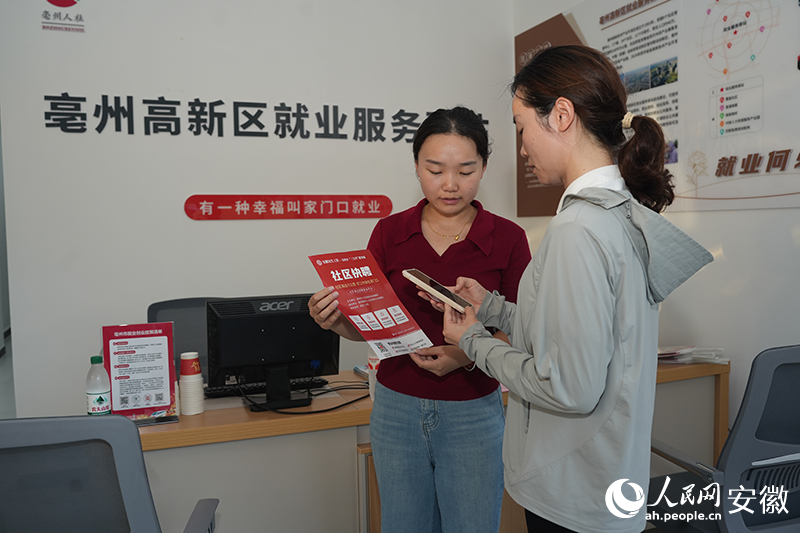 居民在就业服务驿站里通过扫码了解附近招工单位信息。