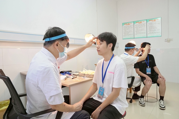 医护人员正在给应征青年做检查。