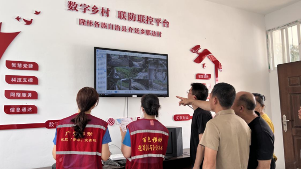 移动工作人员和村干部通过中国移动数字乡村平台查看乡村治理工作情况。吴菁菁摄