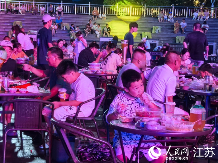 外地游客在兴化市乌巾荡湿地公园品虾看“苏超”直播。