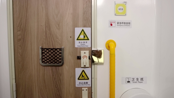 普惠型适老化旅游列车卫生间内新增的紧急报警按钮和L形扶手，还有加大加宽的提示标志。邢星摄