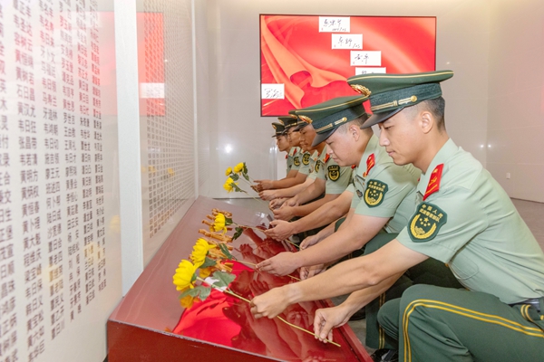 武警官兵向烈士墙敬献鲜花。