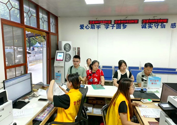 “愛心助學” 牆下，黃馬甲托舉的求學遠方。林桂冰攝