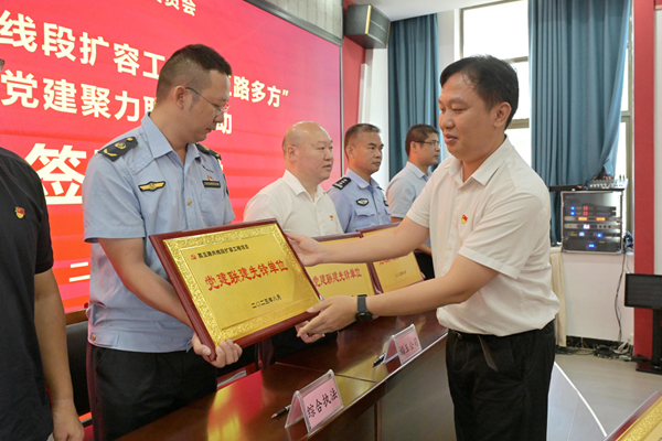 邓祥明为参与联建的单位授予牌匾。梁焕摄