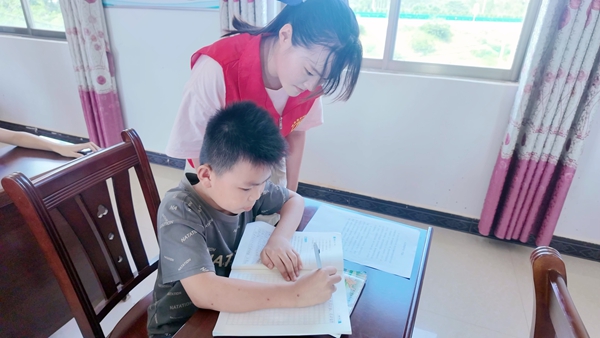 志願者輔導孩子完成暑期作業。