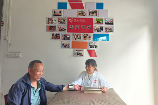 具有村医身份的农网终端店主粟林弟在为村民测量血压 唐俊摄