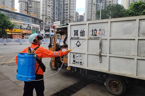 图为环卫工人在对环卫作业车辆进行消杀
