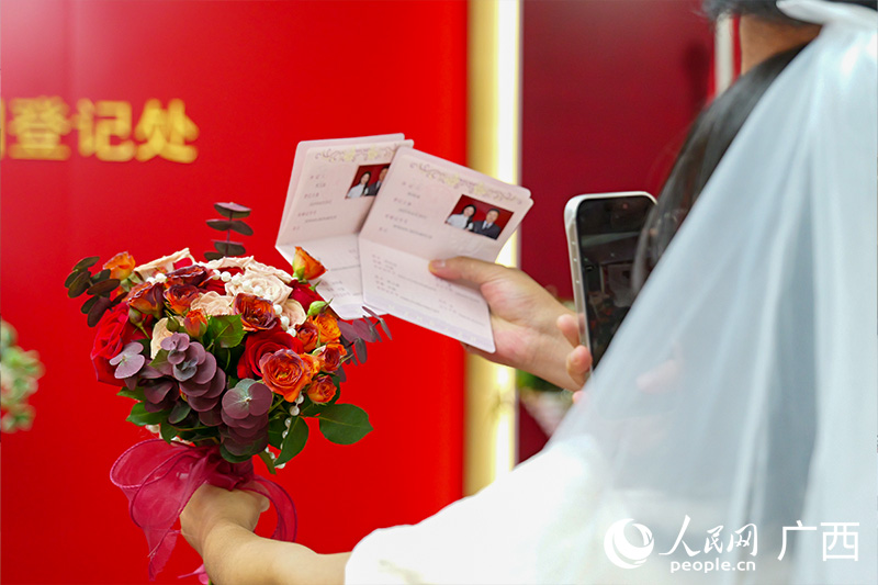 新人拍摄自己的结婚证。人民网 梁章晖摄