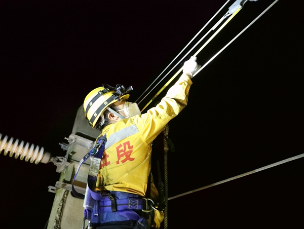 青年職工正在測量補償裝置滑輪間距。柯群威攝